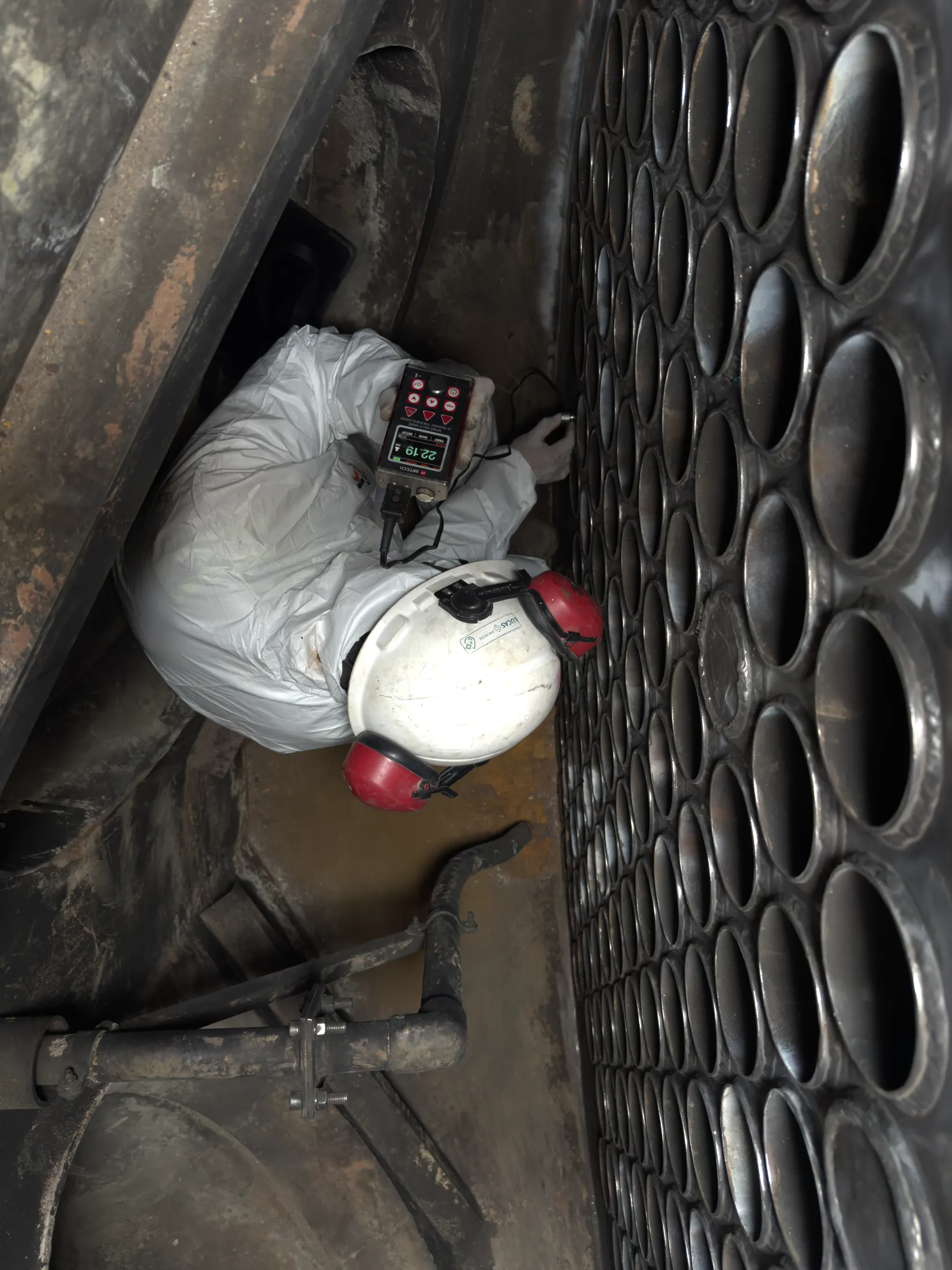 Profissional da ENGNOSE realizando medição de espessura por ultrassom em equipamento industrial